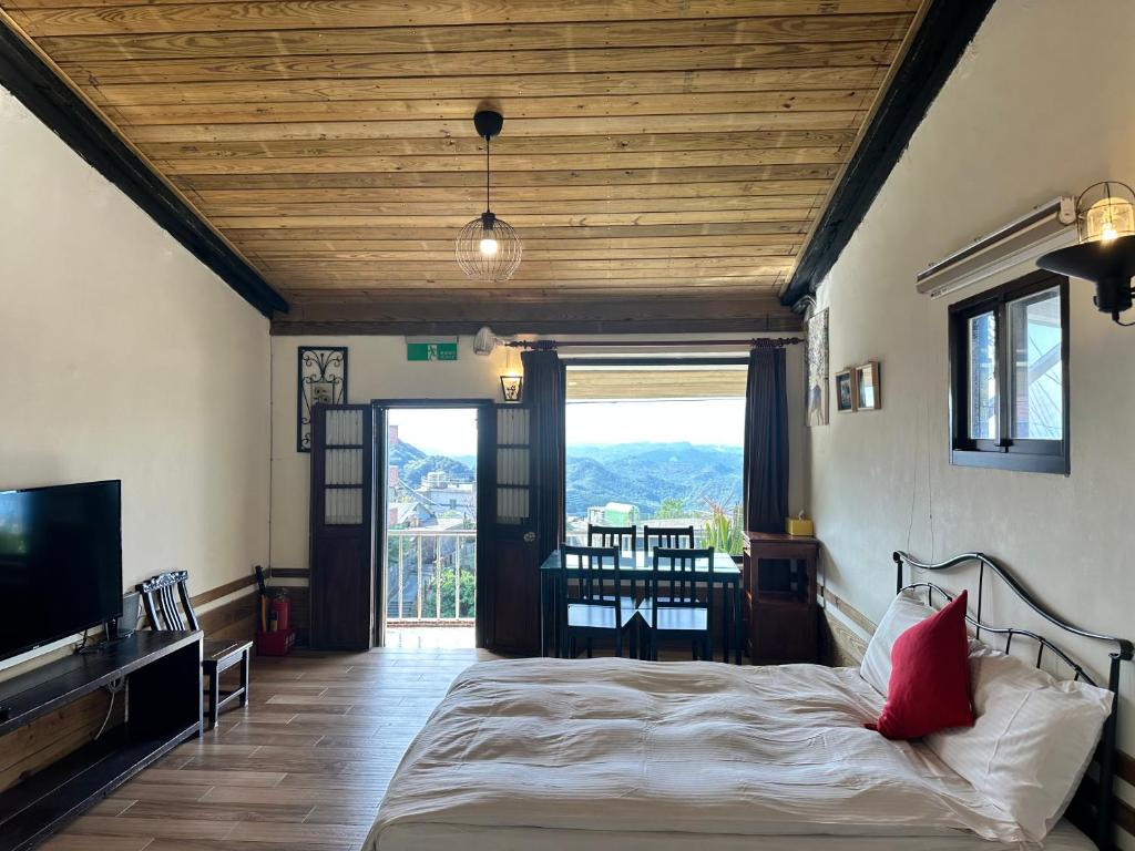 a bedroom with a bed and a large window at 九份迦南民宿 in Jiufen
