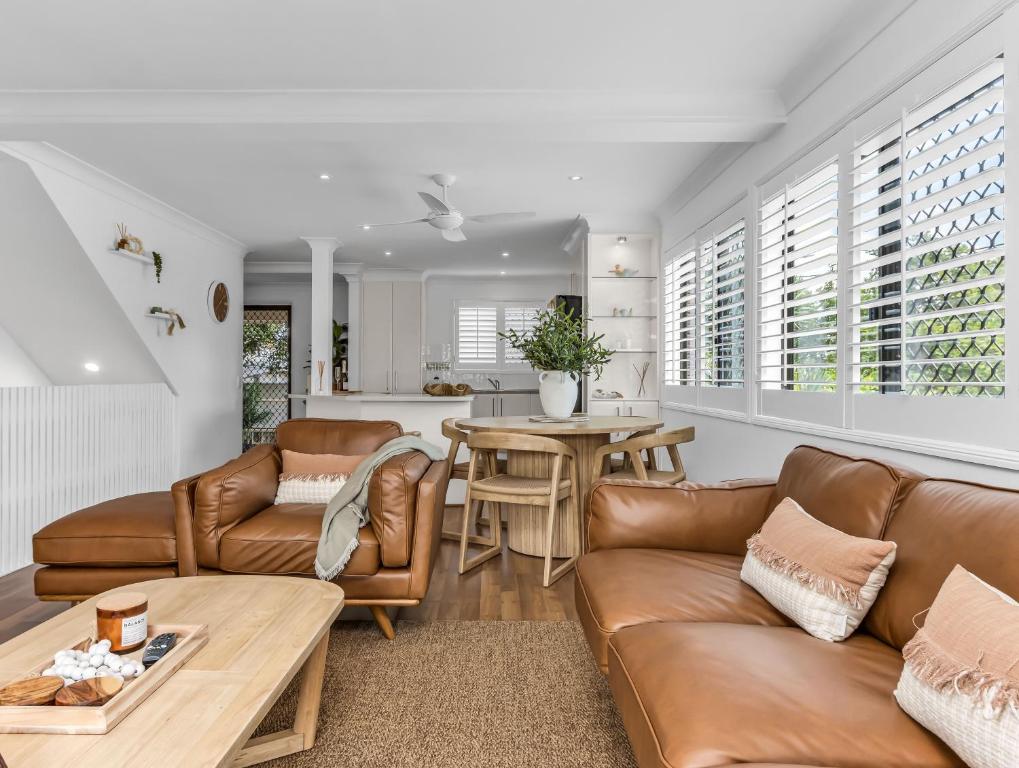 a living room with leather furniture and a table at Wave Whisperer in Kingscliff