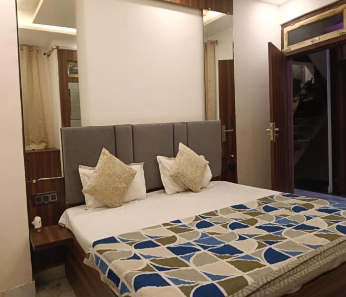 a bedroom with a bed with a blue and white comforter at Hotel Kaushalya in Ayodhya