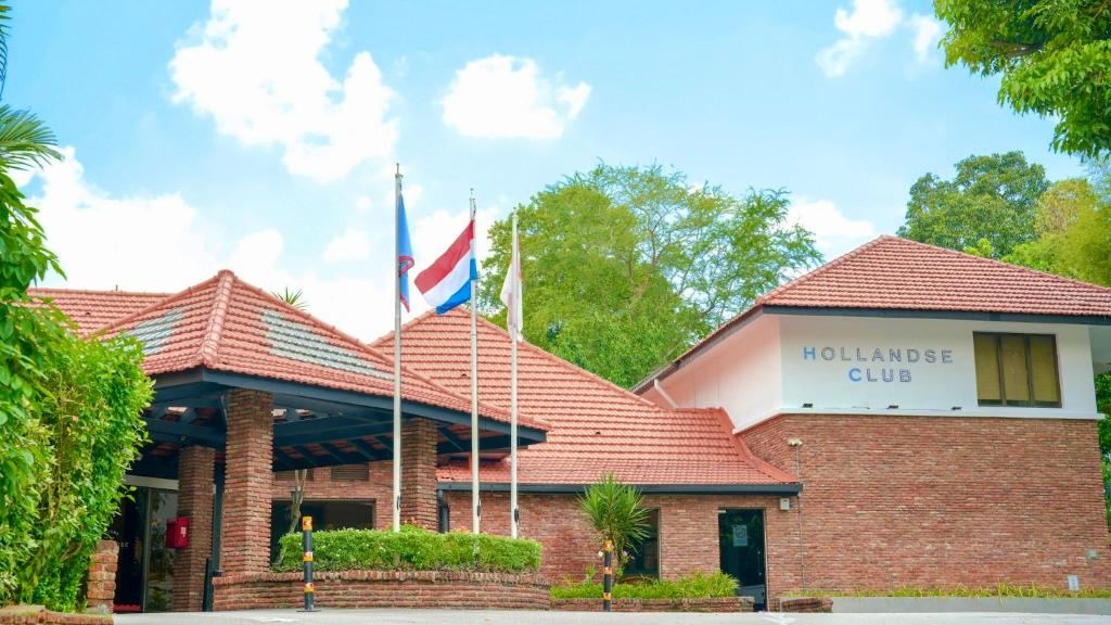 a red brick building with flags in front of it at Hollandse Club Retreat in Singapore