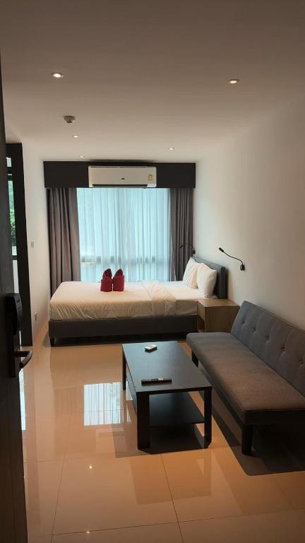 ein Hotelzimmer mit einem Bett und einer Couch in der Unterkunft Utopia Central in Ban Nong Chaeng