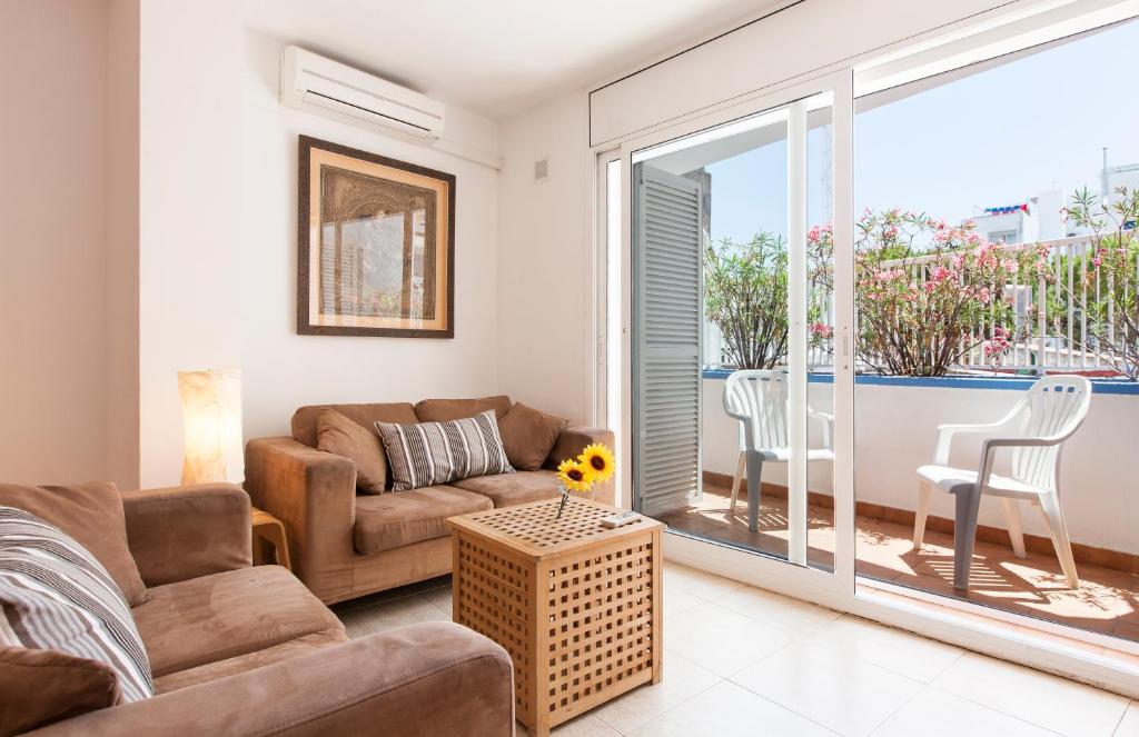 a living room with a couch and a table at Viva Sitges - Sitges Central Apartment in Sitges
