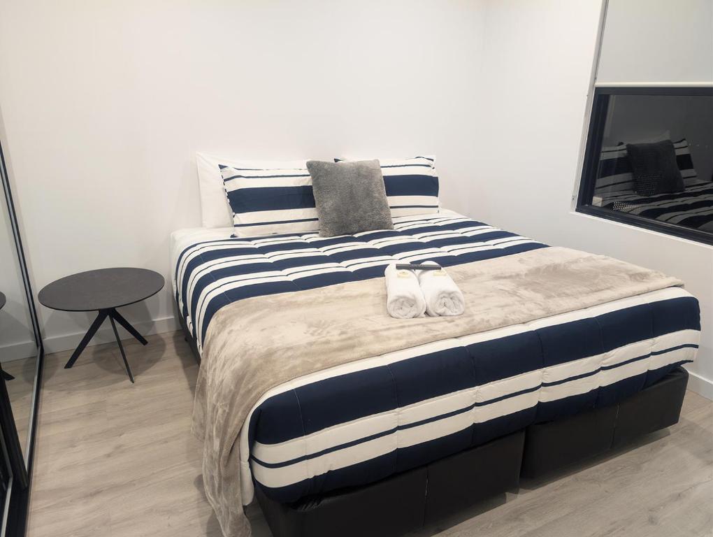 a bedroom with a bed with two white shoes on it at Munibung Apartments in Cardiff