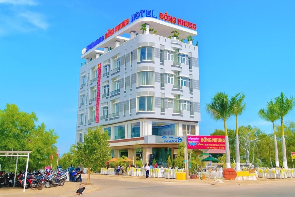 ein großes weißes Gebäude mit Menschen, die draußen stehen in der Unterkunft Hồng Nhung Hotel Kiên Giang in Rạch Giá