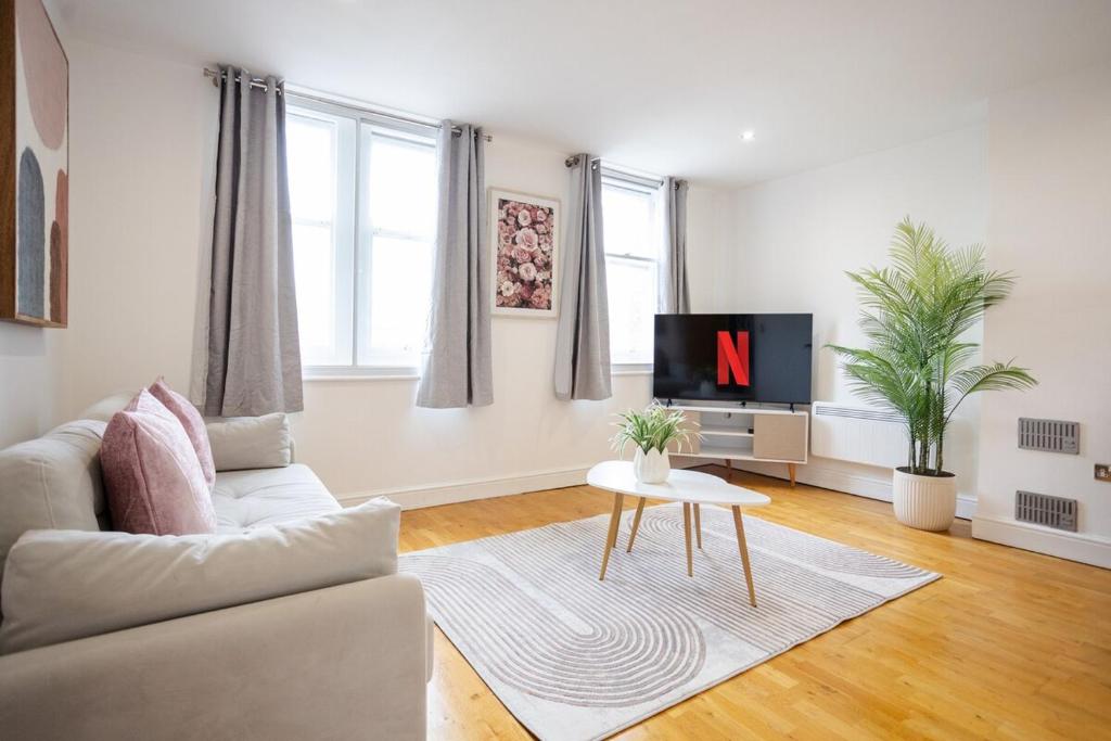 a living room with a couch and a tv at Stylish 1BR Apt near Cardiff Castle in Cardiff