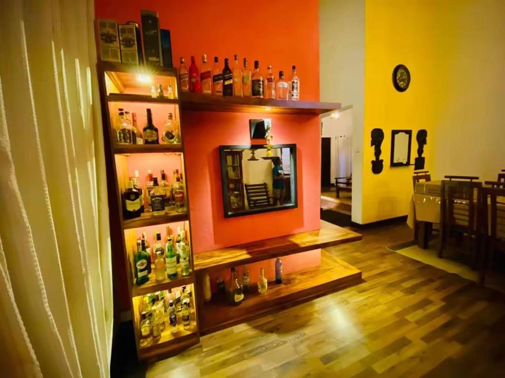 ein Raum mit einer Bar und einem Regal mit Alkoholflaschen in der Unterkunft Cottage Purana in Bandarawela