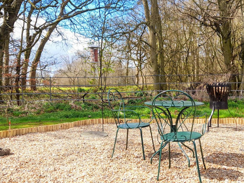 two chairs and a table in a park at Woodlands in Sewerby