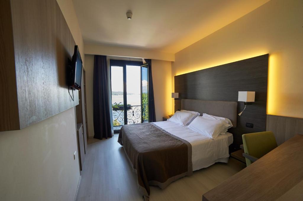 une chambre d'hôtel avec un lit et une fenêtre dans l'établissement Hotel Giardino, à Arona