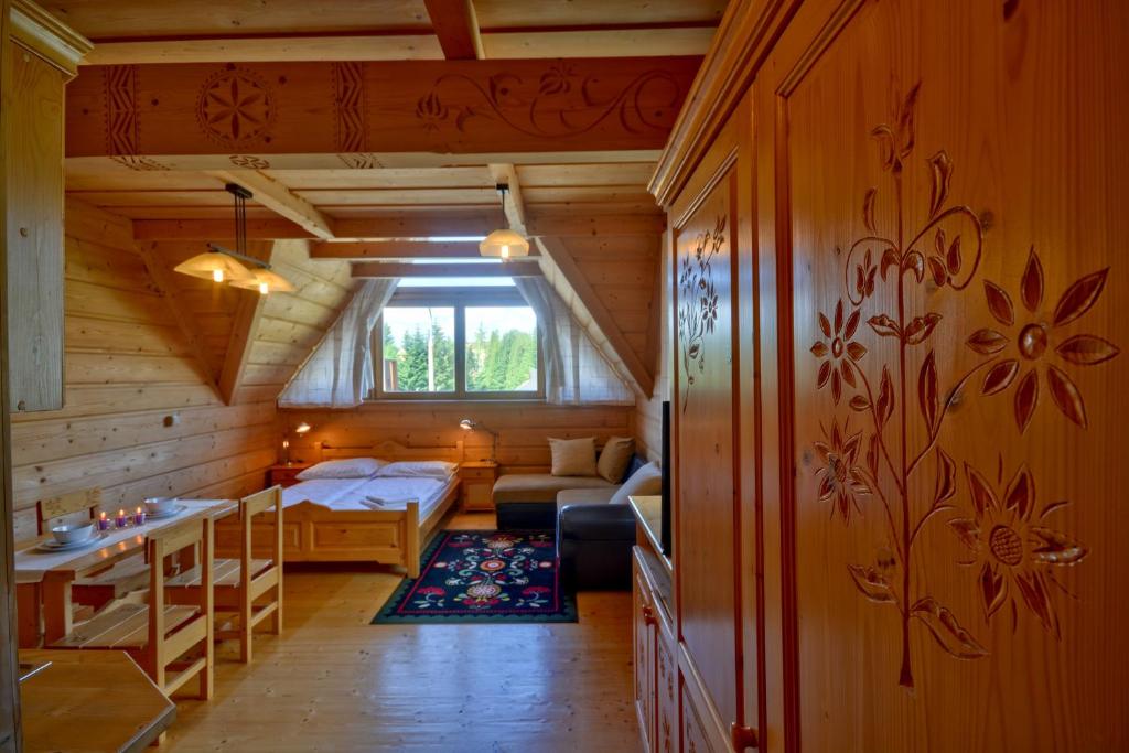 una camera con un letto e un divano in una cabina di ARKA POKOJE DE LUX a Kościelisko