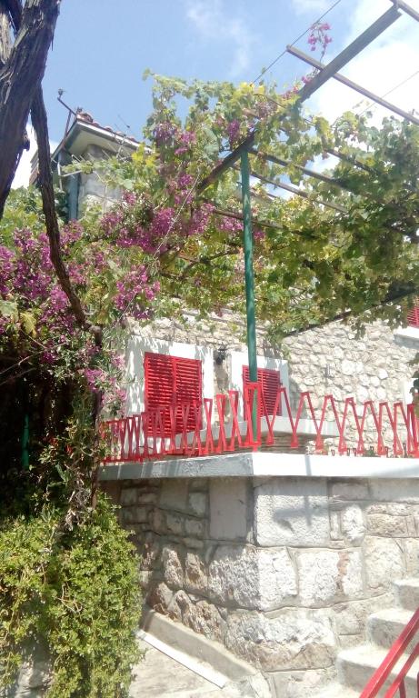 two red chairs sitting on top of a stone wall at Stone House in Buljarica in Petrovac na Moru