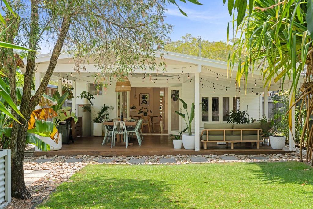 a porch of a house with a table and chairs at The Palma your Leafy Tropical Escape in Moffat Beach in Caloundra