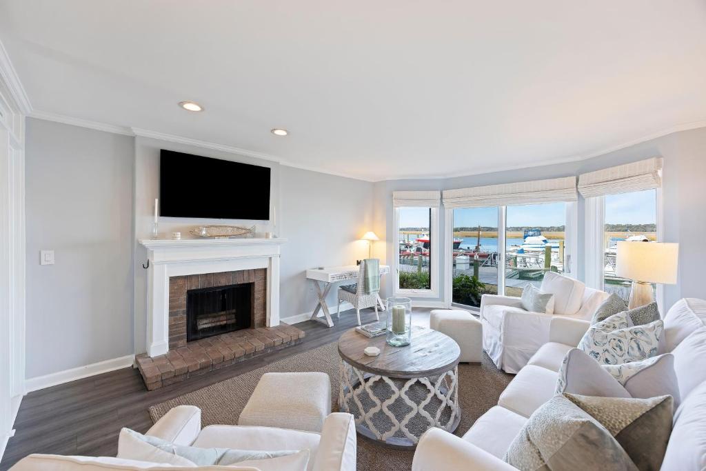a living room with white furniture and a fireplace at BMV1903: 1903 Bohicket Marina Villa in Seabrook Island