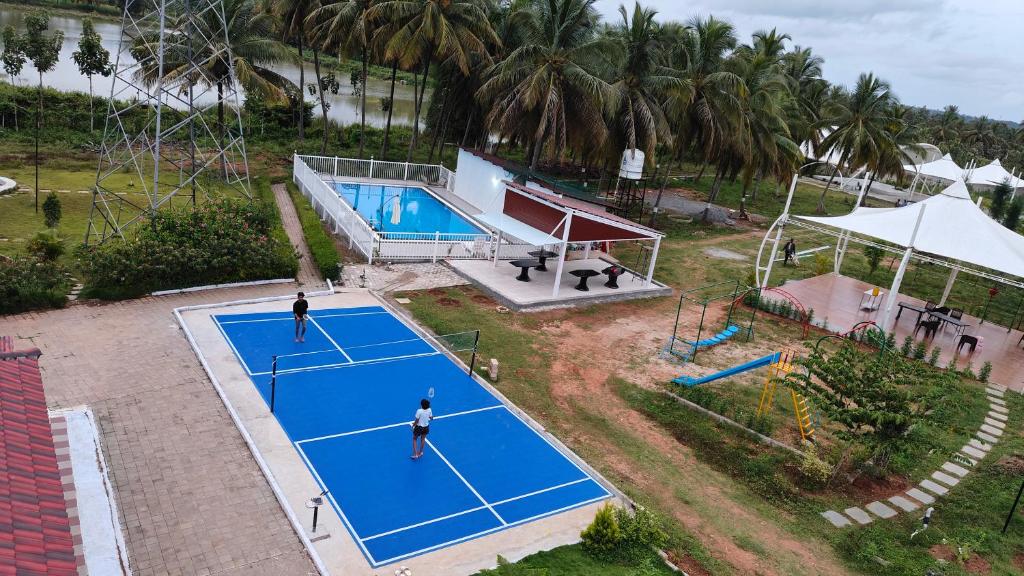 an overhead view of a tennis court with two people on it at Encanto Farmstay Resort in Mysore