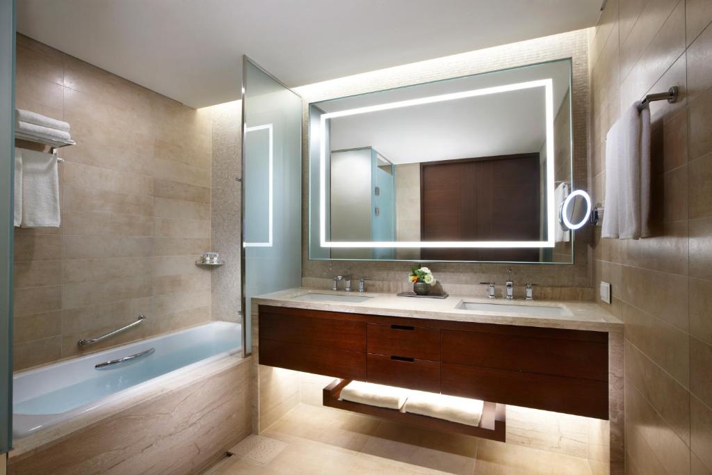 テジョンにあるLOTTE CITY HOTEL Daejeonの洗面台、浴槽、鏡のあるバスルーム