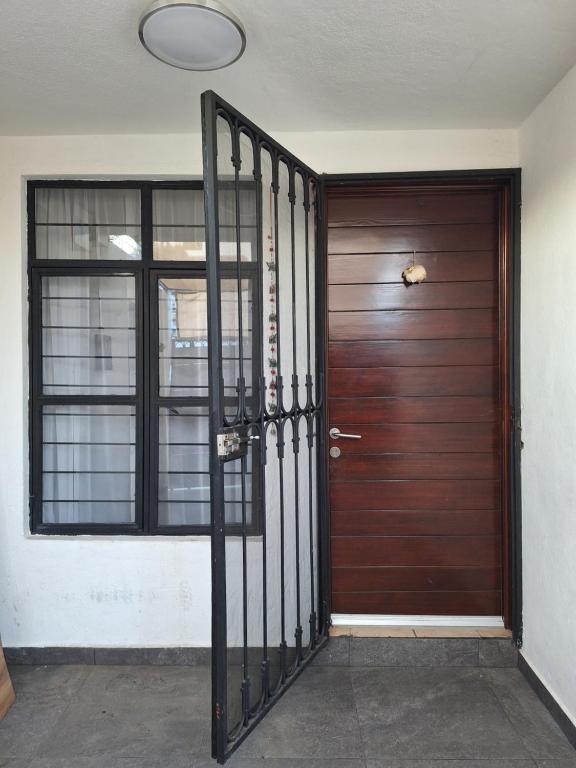 a wooden door with a metal gate in front of it at Casa Ana Victoria in Morelia
