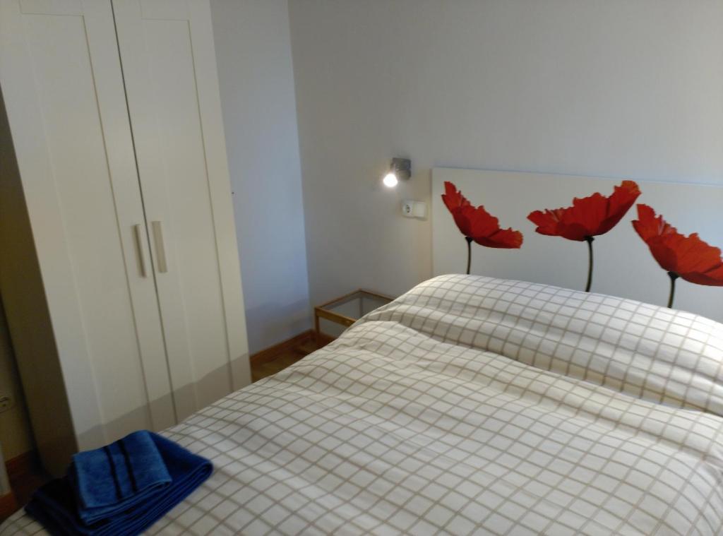 a bedroom with a bed with red flowers on it at Madrid Rent 6 in Madrid