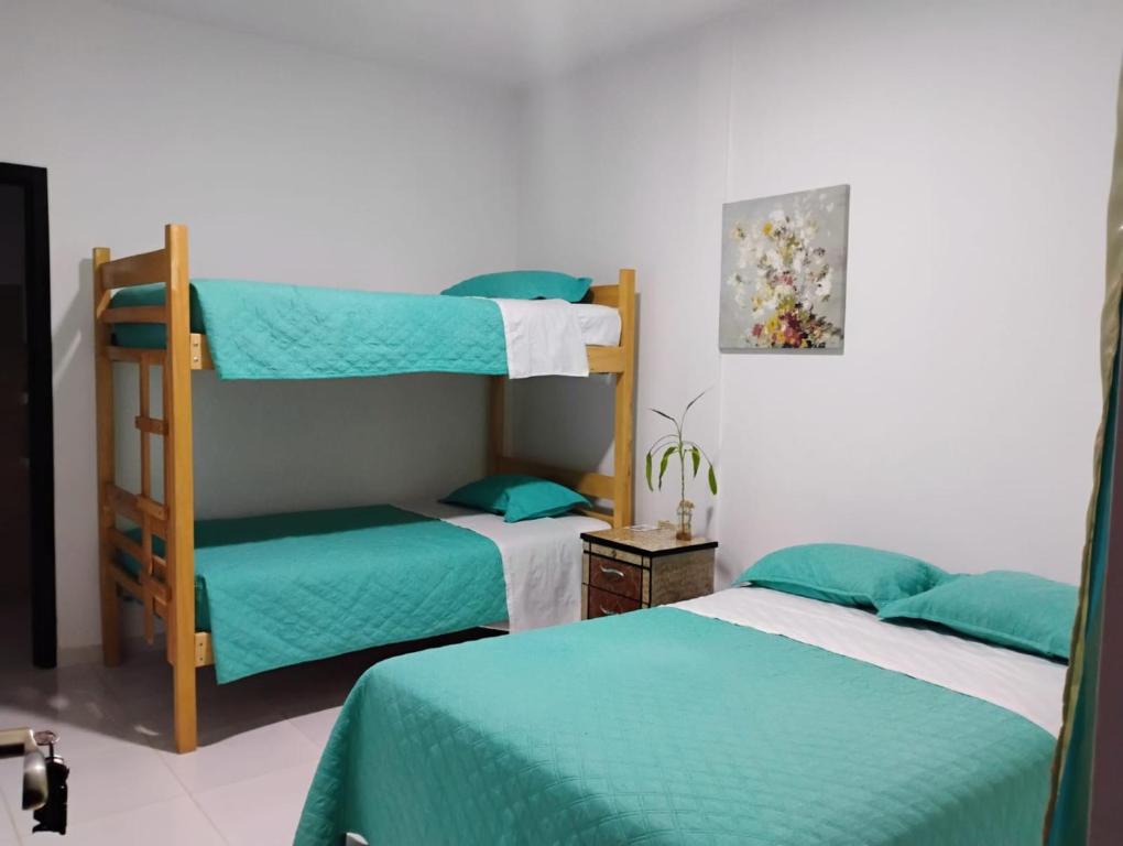 a bedroom with two bunk beds and a chair at Hosteria La Veleta, Playas in Playas