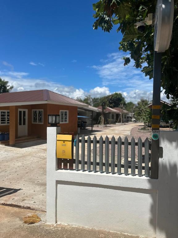 a white fence in front of a house at NADOHN-Homestay in Ban Nam Lai Ta Tum