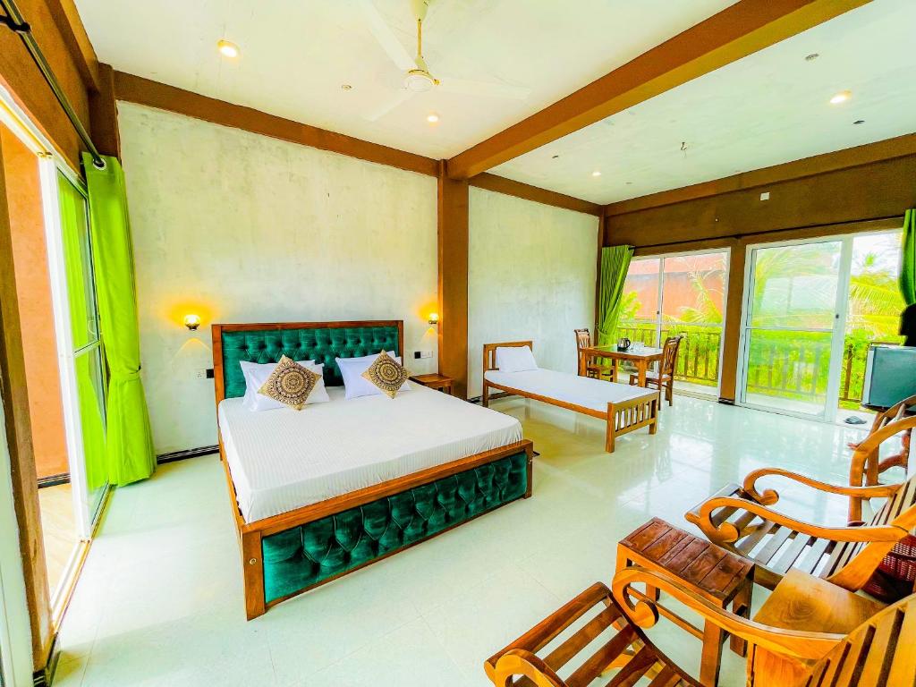 a bedroom with a bed and a chair in a room at Blowhole Unawatuna in Unawatuna