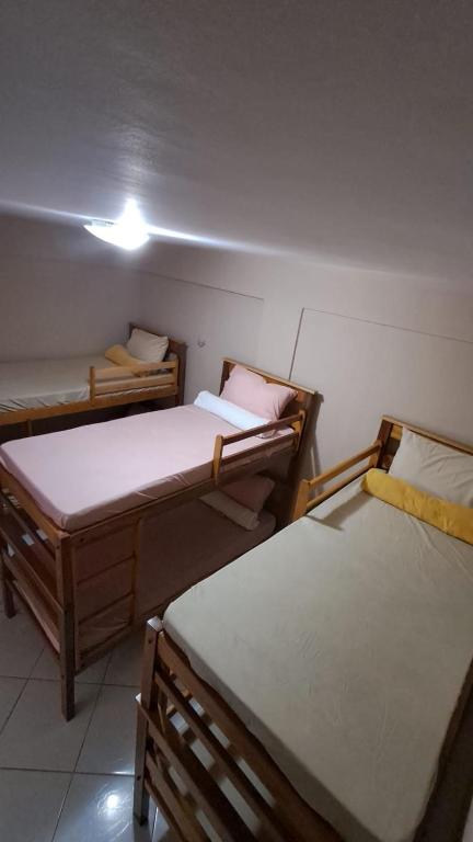 a room with three beds in a room at Hostel Tiquinho in Belém