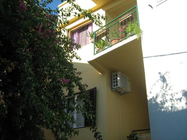 a building with two balconies and a plant at Apartments Knežić in Igrane