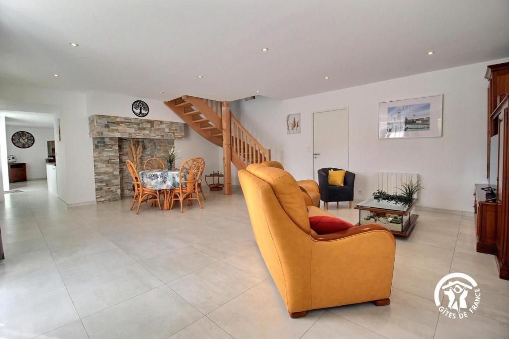 a living room with a couch and a chair and a table at Longere du gaudin in Pluherlin