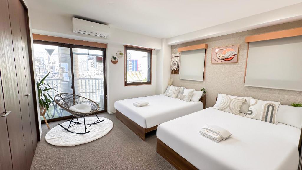 a hotel room with two beds and a window at Ansou house 大阪ドーム in Osaka