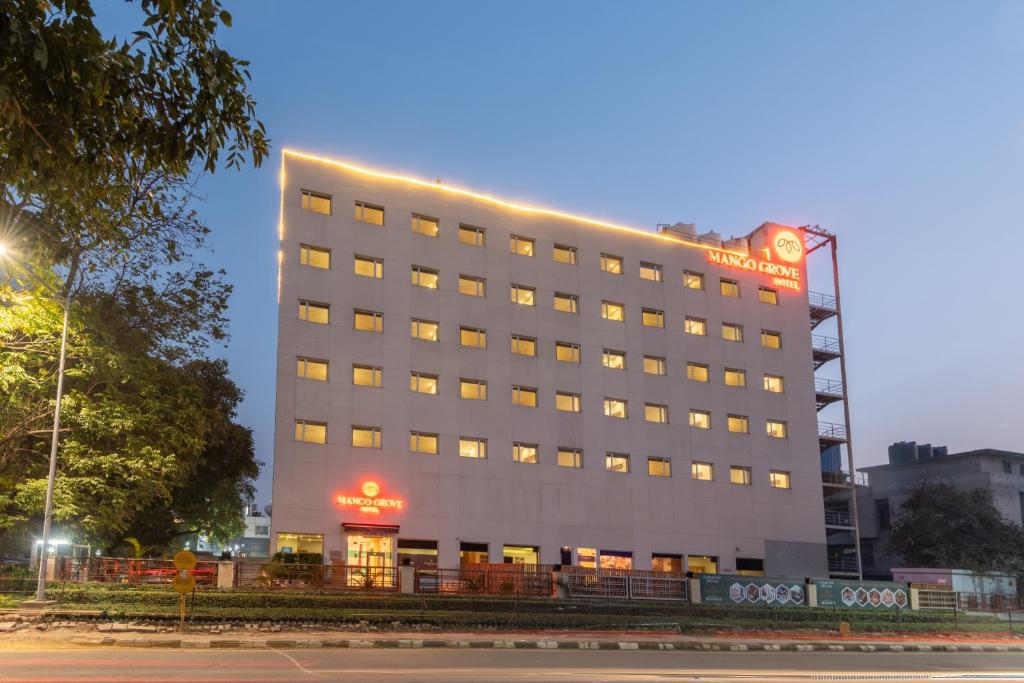 un bâtiment d'hôtel avec une enseigne au sommet dans l'établissement Mango Grove Hotel, à Chandigarh