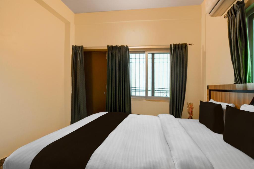 a bedroom with a large bed and a window at Super Hotel O Birsa Athletics Stadium Formerly De Anmol Suites in Nāmkom