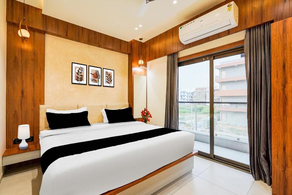 a bedroom with a large bed and a window at Super Townhouse GIDC Bol Sanand in Ahmedabad