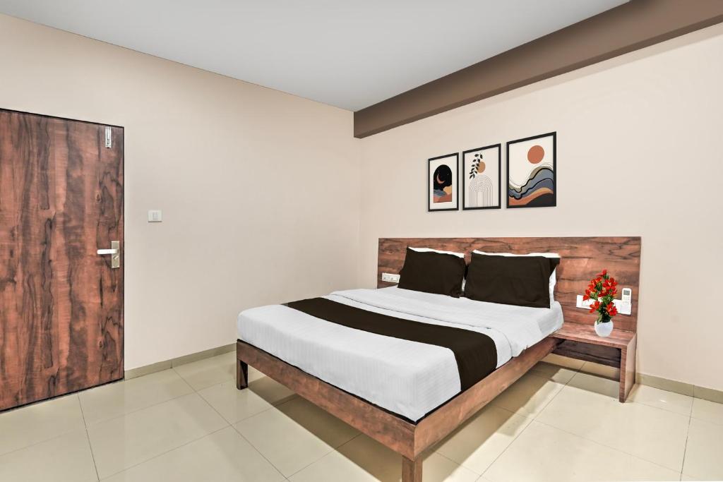 a bedroom with a large bed and a wooden door at Super Collection O Palampur Surat Formerly Hotel Royal Paradise in Bhatha