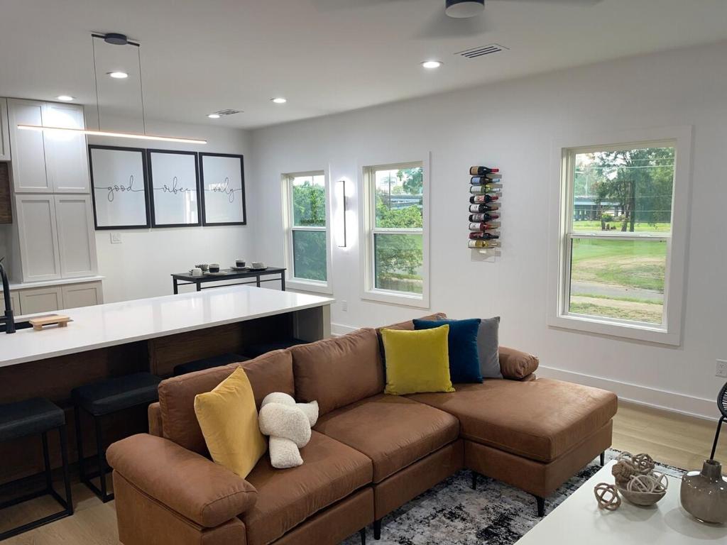 a living room with a couch and a kitchen at Downtown New 3 Story Sleeps 14 in Baton Rouge
