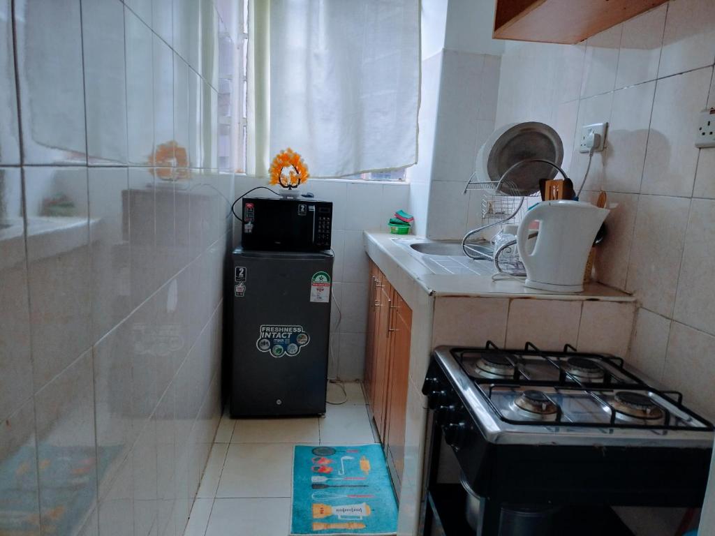 een kleine keuken met een fornuis en een kachel bovenste oven bij Cutie homes -Trm drive in Nairobi
