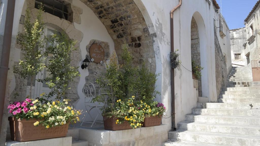 two potted plants on the side of a building with stairs at Casa MaFaCò in Modica