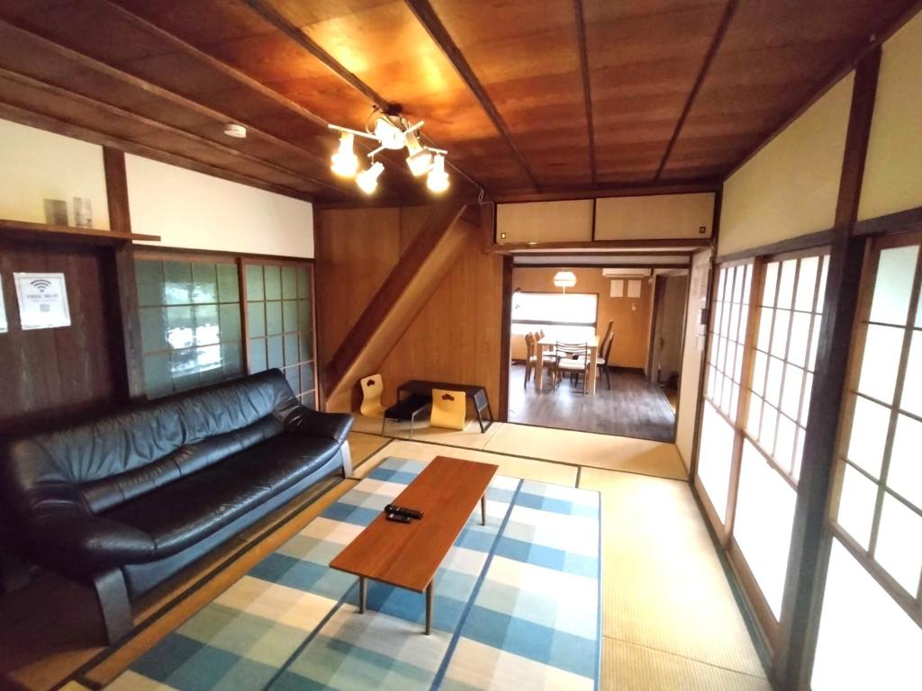 a living room with a couch and a coffee table at たけのこ古民家いちはらキッズベース in Ichihara