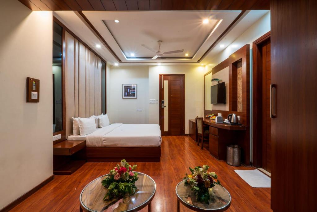 een hotelkamer met een bed en twee tafels bij Hotel Grand FFOUR in New Delhi