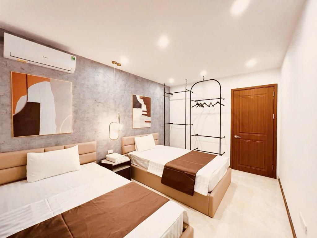 a hotel room with two beds and a mirror at Homestay Greenbay Garden in Ha Long