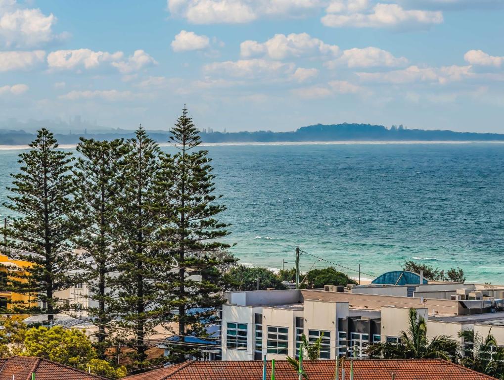 a view of the ocean with buildings and trees at Humpback Villa in Kingscliff