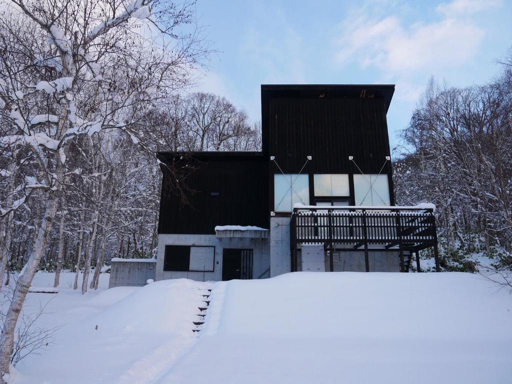 a house in the snow with a pile of snow at 【愛犬と泊まれる宿】NISEKO RIKYU －利休－ in Kutchan