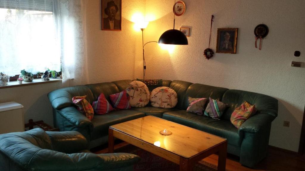 a living room with a green leather couch and a coffee table at Monteurhaus Villa Rotter in Altenstadt an der Waldnaab