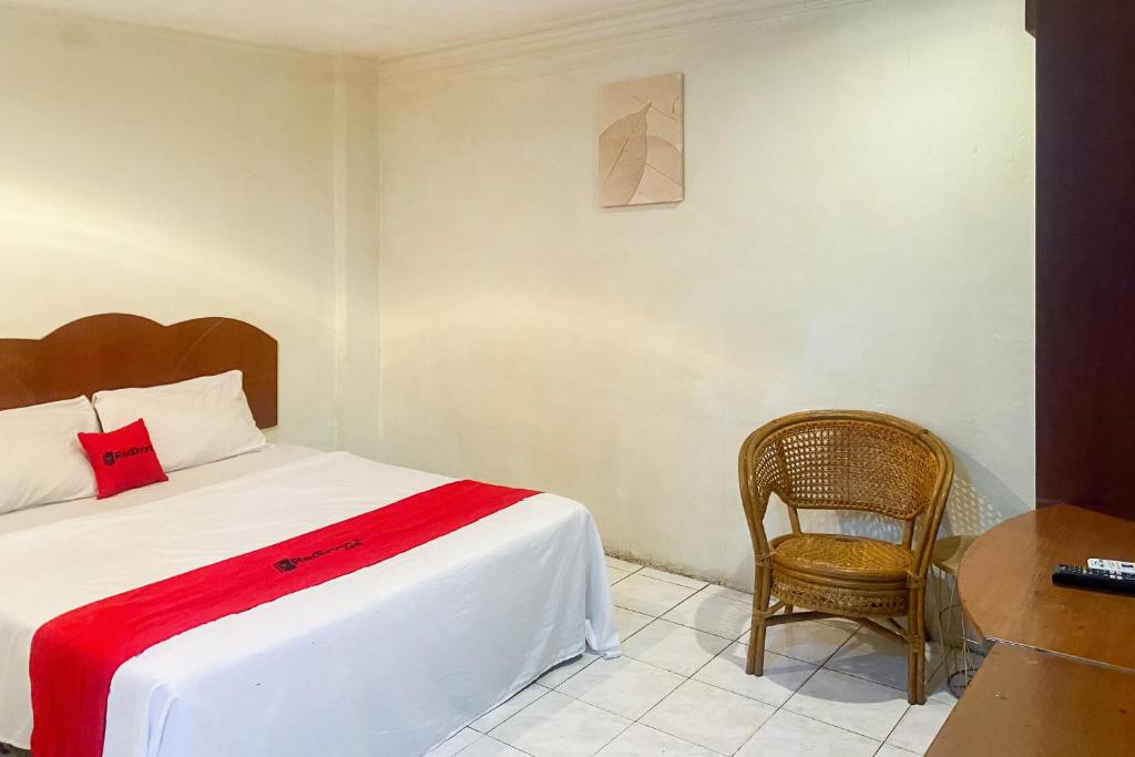 un dormitorio con una cama y una silla en RedDoorz at Hotel Memory Batam, en Jodoh
