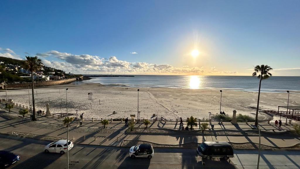 a parking lot with cars parked on the beach at Edificio La Rue- frente al mar in Piriápolis