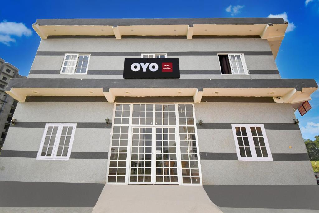 Un edificio blanco y negro con un cartel en él. en SPOT ON Hotel Gold Inn, en Bheta