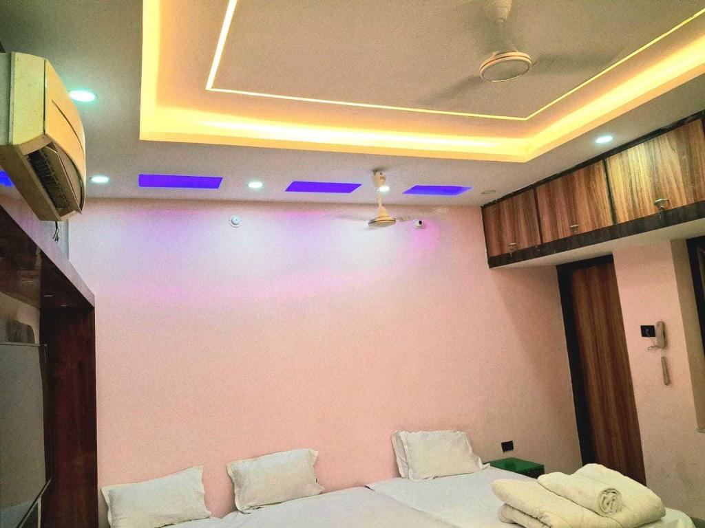 a room with a couch and a pink wall at Hotel O Raj Mahal INN in Gulzārbāgh