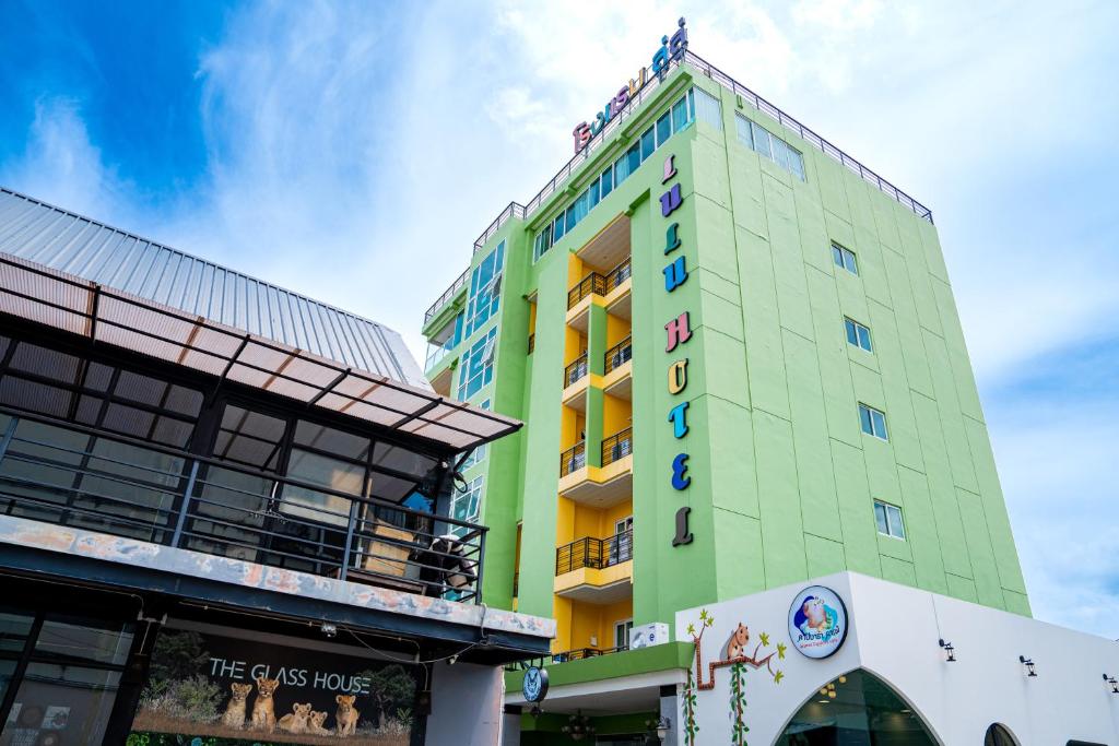 Ban SireにあるLulu Hotel at The Glasshouse Lion Caféの標識のある高い緑の建物