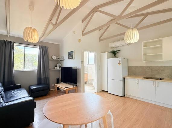 a living room with a table and a kitchen at Beachside Cabin No 1 at Island Beach in Island Beach