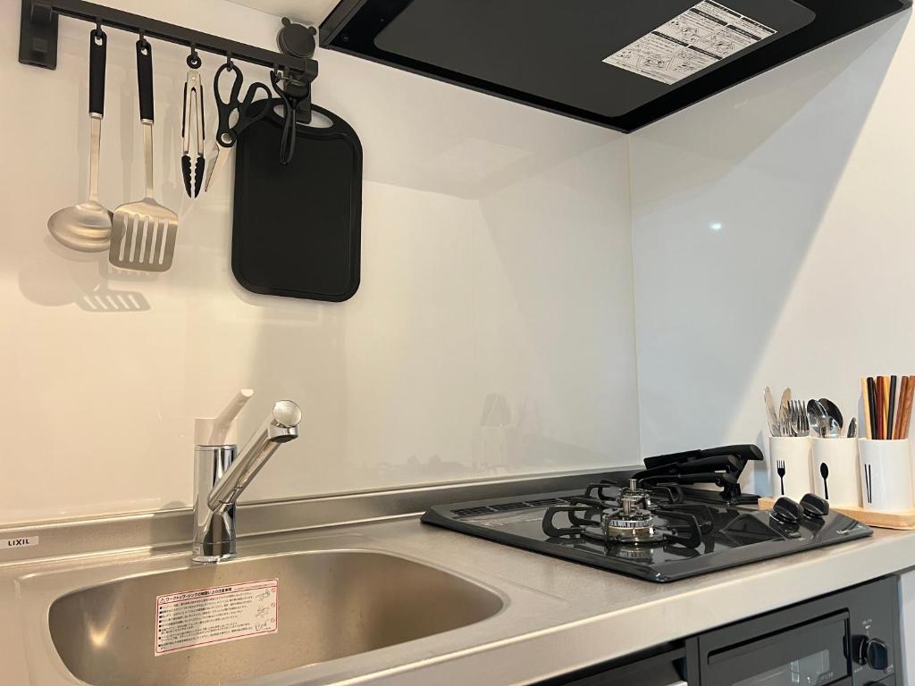 a kitchen with a sink and a stove at ブレイブベース糸島 in Itoshima