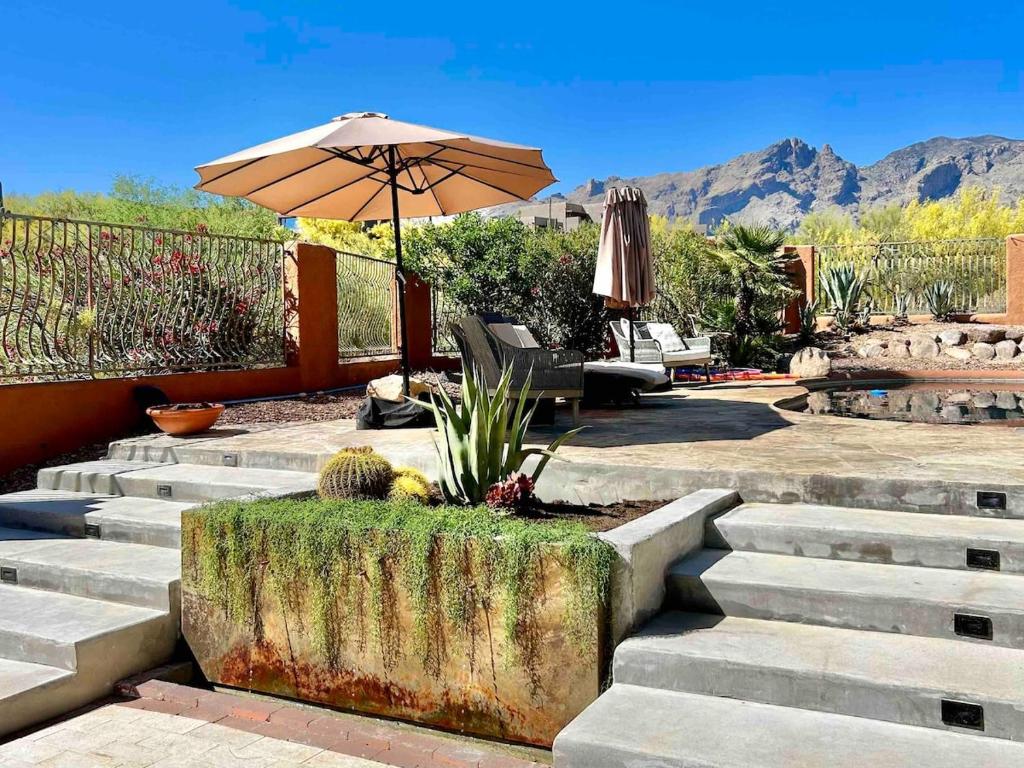 a patio with stairs with an umbrella and a chair at Casa Catalina - Luxury Desert Oasis in Tucson