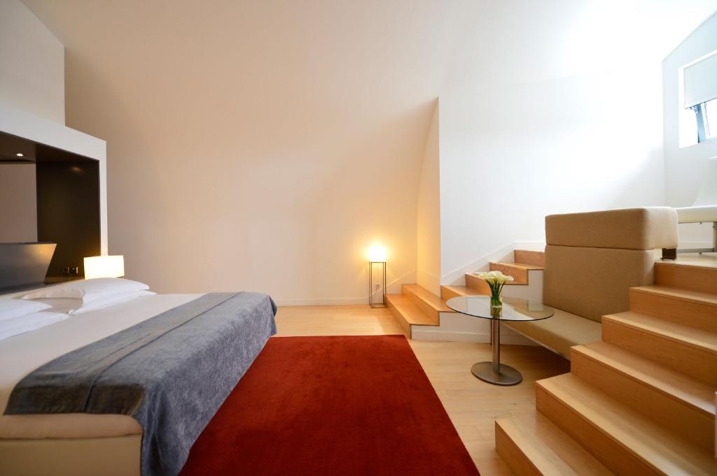 a bedroom with a bed and stairs in a room at Pestana Cidadela Cascais - Pousada & Art District in Cascais