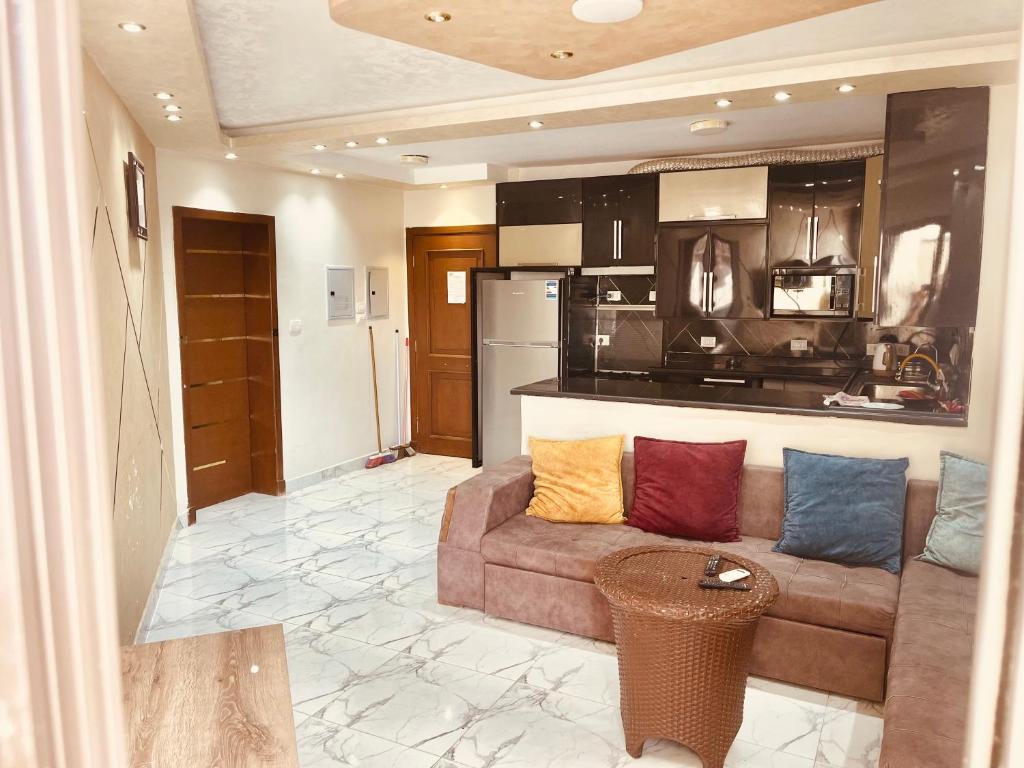 a living room with a couch and a kitchen at بورتو سعيد فندق وشقق مميزة in Port Said